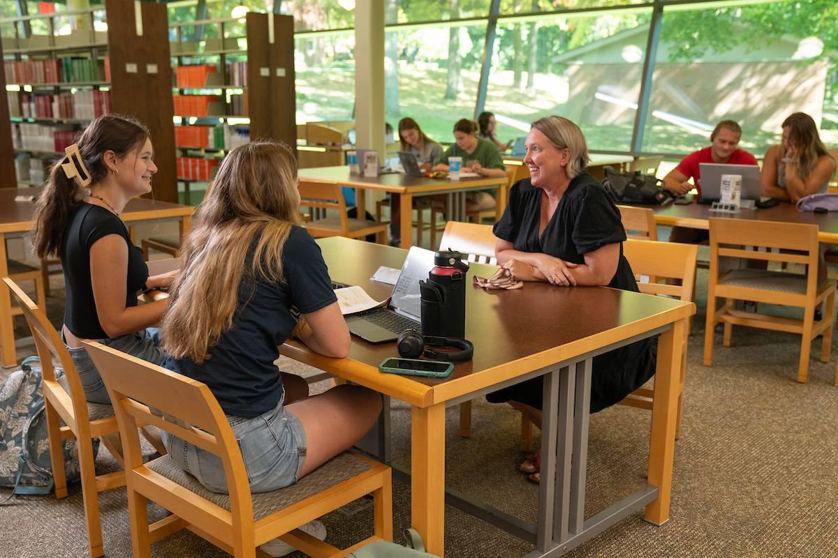 学生和学生成功主任Sara Haviland在图书馆的一张桌子旁交谈